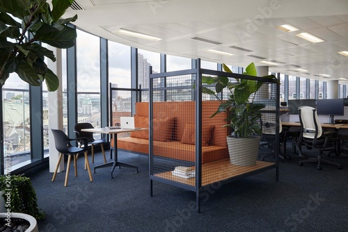 Modern open plan office interior with coworking zone and city view windows