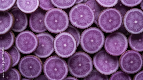 Cross-section slices of raw purple sweet potatoes.