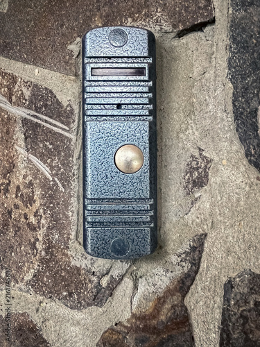 Fotografía Vintage Metal Doorbell Button with Textured Surface on Natural Stone Wall Backgr