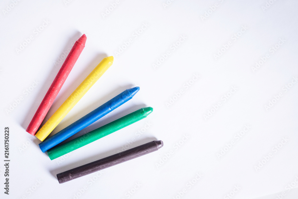 Fototapeta premium Box of soft pastel crayons and colored pencils on creative wooden table, close up