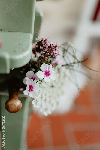 Bild auf Leinwand Wildflowers on a church pew at a wedding ceremony