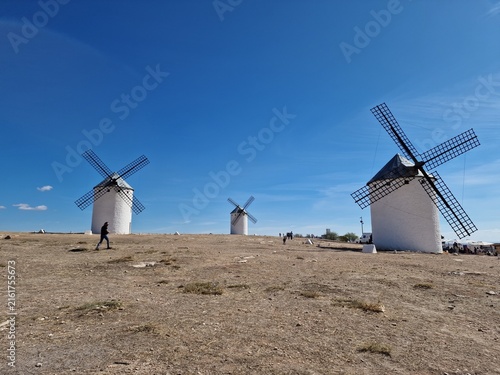 Foto Person walking past historic white windmills in Campo de Criptana, Castilla-La M