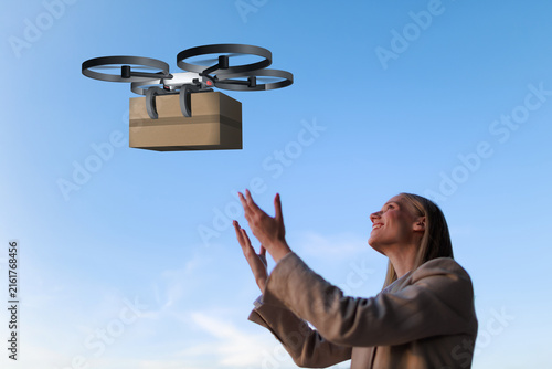 Businesswoman receives drone delivery package in the city