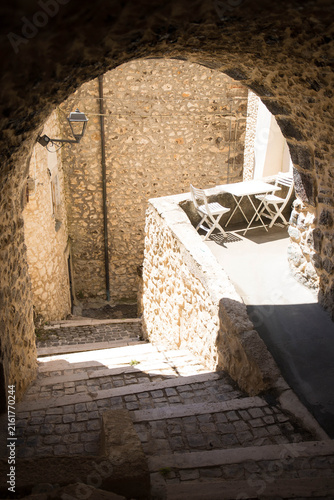 Little pedestral road with staircase and arch near a sunny terrace in the charming village of Castel del Monte, Abruzzo, Italy.