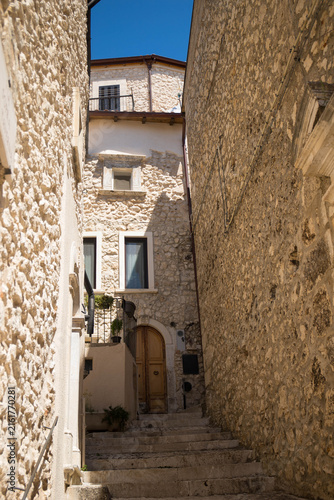 Little pedestral road with stairs and arch on a sunny day in the charming village of Castel del Monte, Abruzzo, Italy.