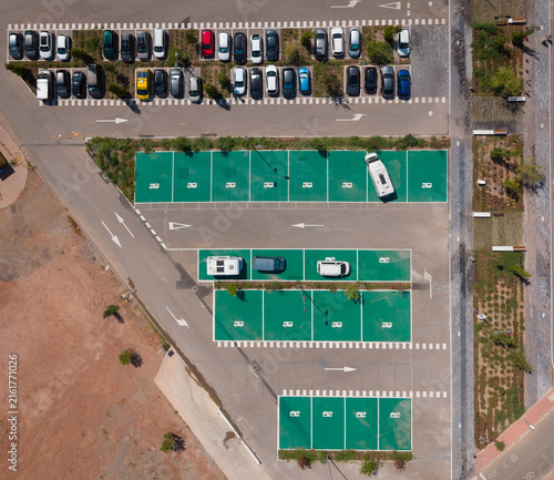 Bird's eye view of a parking area featuring designated green motorhome bays alongside regular car parking spaces, with various vehicles parked in both sections