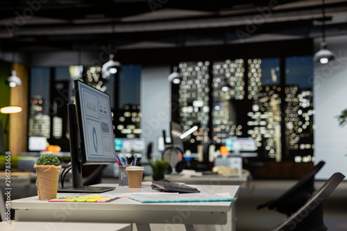 Konstfotografi Empty multinational company office late at night has computers displaying infographics and graphs for data analysis while management objectives remain aligned with corporate planning goals
