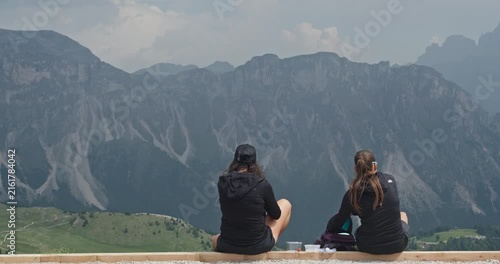 Two women enjoying a meal with a view of the dolomites