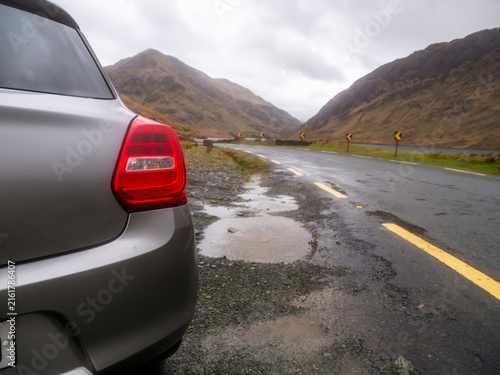 Cuadro en lienzo Silver car on wet road near lake