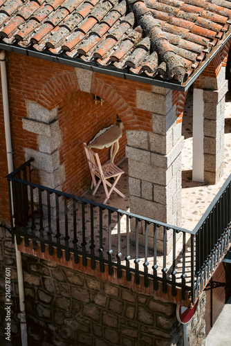 Cozy Spanish Balcony Coffee Spot with Table and Chair Under Brick Arch