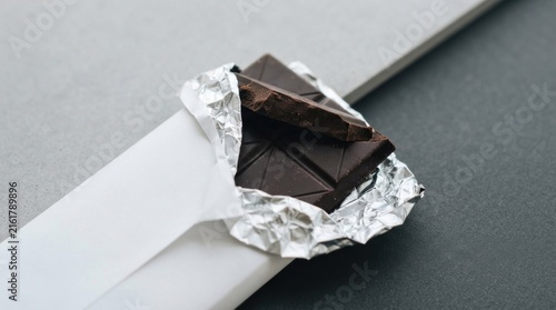 Broken dark chocolate piece in silver foil wrapper