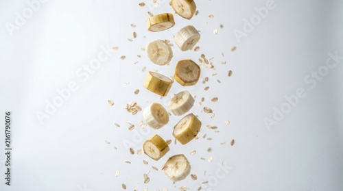 Cascading banana slices and oats on plain background