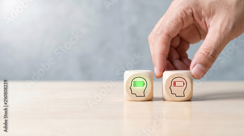 Mental energy and burnout concept with wooden blocks showing full and depleted brain battery levels with copy space.