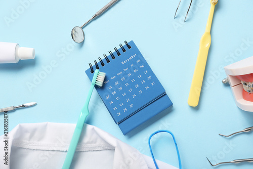 Calendar with dentists supplies on blue background