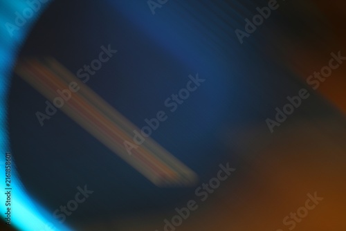 Close-up of a blue object with colorful streaks and blurred background showing abstract vibrant