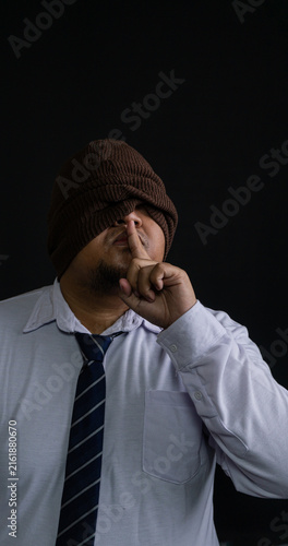 Cuadro en lienzo A mysterious Asian male dressed in professional corporate attire commands absolute silence by pressing a single finger against the lips in a classic shushing gesture