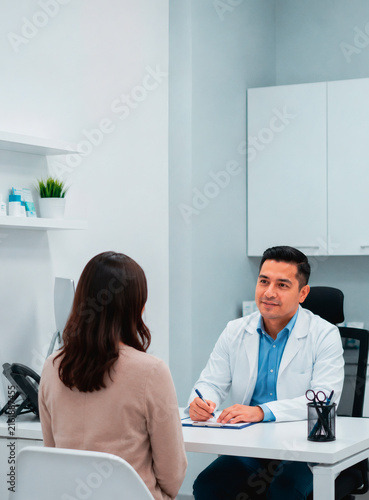 Doctor consulting with patient during medical appointment in modern clinic