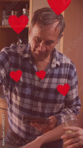 Animation of heart icons over caucasian father and daughter cooking