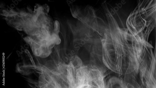 Cuadro en lienzo Soft plumes of white smoke dance and intermingle in the darkness, forming intricate patterns with a sense of ethereal movement