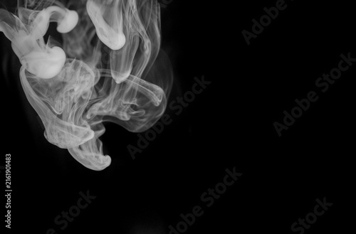 фотографія Fluid streams of white smoke descend and dissipate, creating an abstract cascade of ethereal forms against the darkness