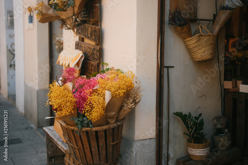 Фотография Flower shop entrance decorated with colorful dried mimosa bouquets on Madrid str