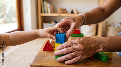 Adult and child hands building with colorful wooden blocks on a table, close up shot
