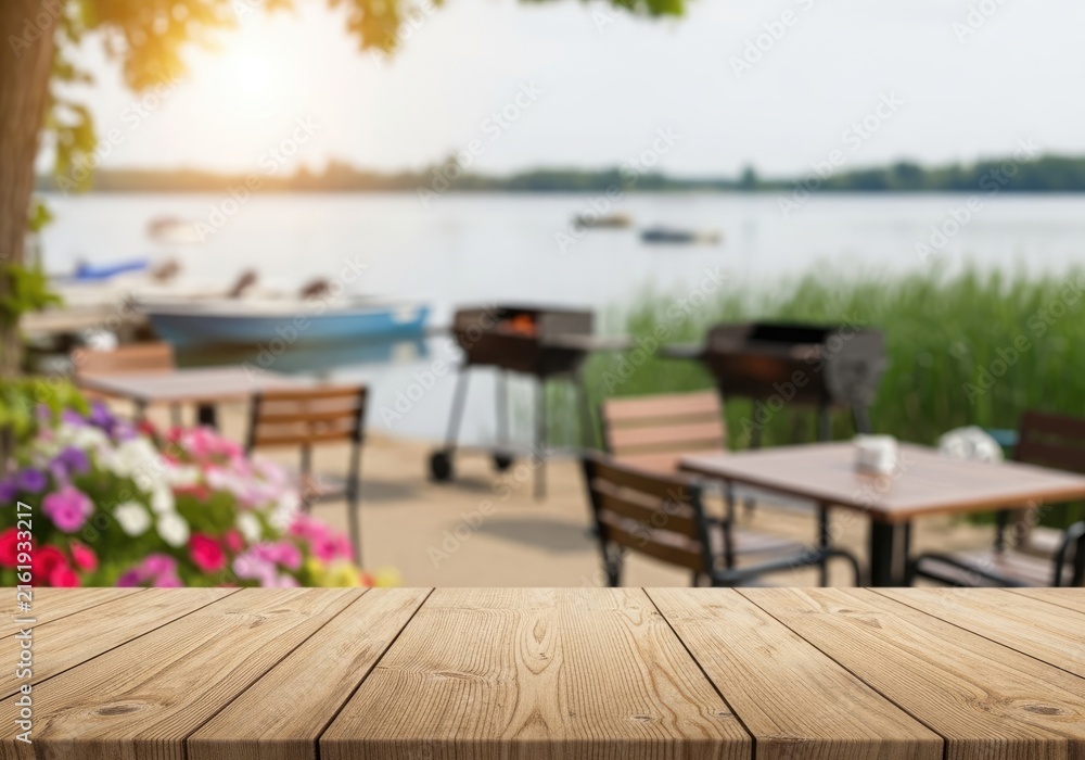 Fototapeta premium Outdoor Lakeside Dining Area with Grills and Boats.