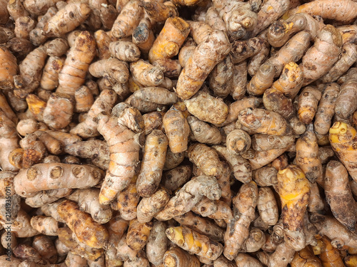 Fotografía overlapping pile of whole raw turmeric rhizomes (Curcuma longa), commonly known