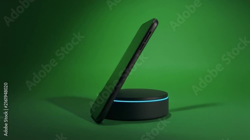 Black smartphone charging on circular wireless dock against green background in smooth digital motion footage clip