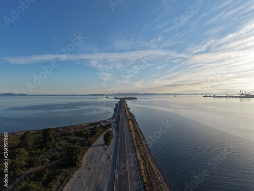 Fotografie Low angle aerial shot of asphalt causeway crossing sea water