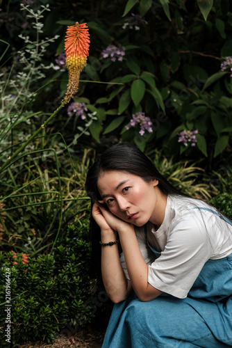 Sticker Young woman contemplating in a vibrant summer garden