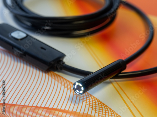 Close-up of a modern USB endoscope inspection camera with illuminated LED lights on a flexible black cable
