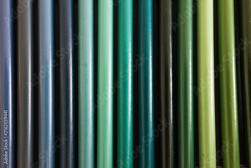 close-up of blue turquoise and green colored pencils neatly lined up in pencil case, concept of creativity, drawing, education and art supplies
