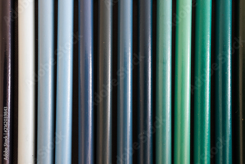 close-up of blue turquoise and green colored pencils neatly lined up in pencil case, concept of creativity, drawing, education and art supplies