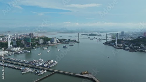 Drone footage overlooking Ha Long Bay, featuring the Quang Ninh waterfront, harbor, marina, islands, cable car, vessels, and coastal city landscape.