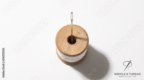 Cuadro en lienzo Sewing needle logo and wooden thread spool on white background