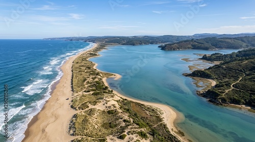 Breathtaking aerial view of a long sandy beach spit separating a tranquil blue lagoon from the rolling ocean waves
