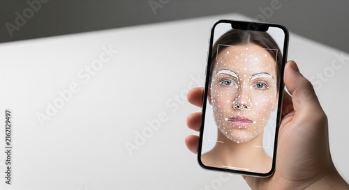 Woman checking smartphone selfie reflection in well-lit indoor setting