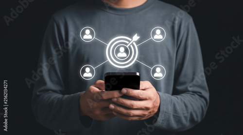 Man using smartphone with digital target and people icons, representing recruitment and ideal candidate selection