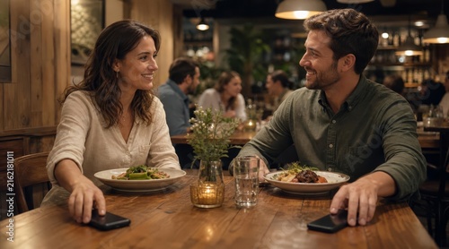 Couple putting smartphones away at restaurant table