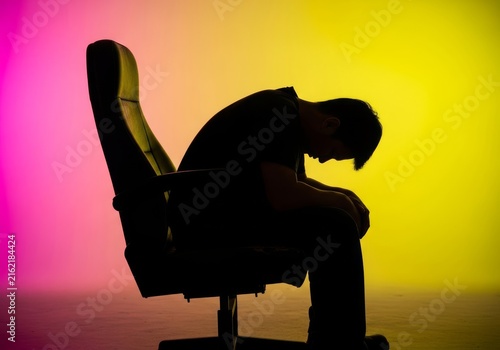 Exhausted silhouette slouched deeply in a dark seat. The tired posture reflects a long day of hard labor and overwhelming mental fatigue, workplace, labor, slouching