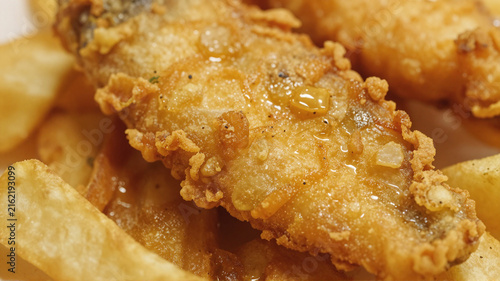 Crispy battered fish fillet served with golden french fries in a close up food photography shot