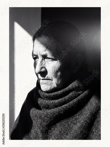 Contemplative portrait of an older person using dramatic chiaroscuro lighting
