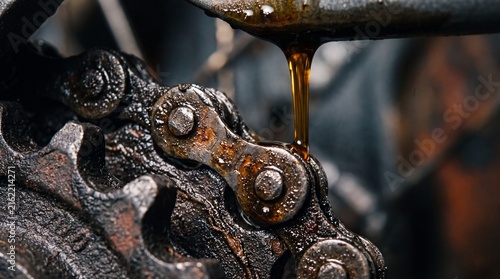 Dirty industrial bicycle chain mechanism coated in oil and rust.