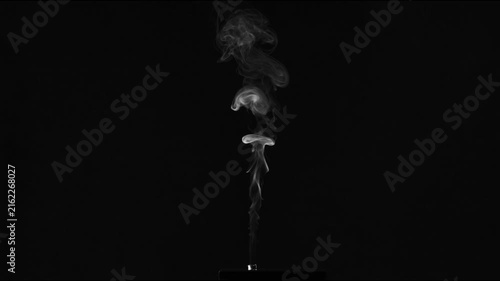 White smoke plume rising against a black background