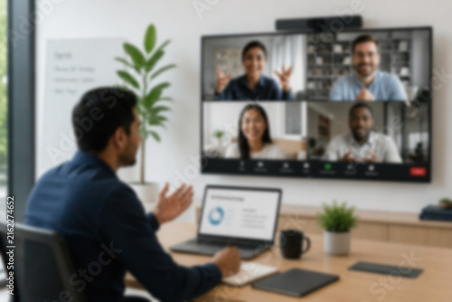 Blurred Hybrid Meeting With An Employee In The Office And Remote Colleagues Joining On Screen