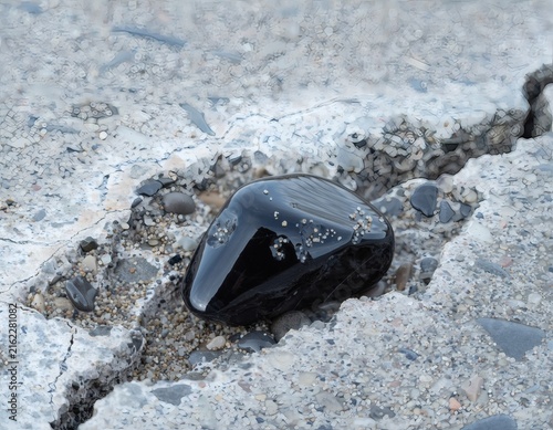 Obsidian Stone Beside Concrete Crack Evoking Urban Decay and Material Contrast