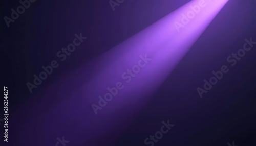 Foto A purple spotlight shines brightly in a dark room with a beam of light