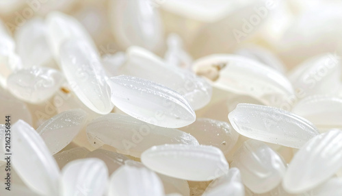 Close-up macro shot of many uncooked white rice grains showing their translucent texture and individual shapes.