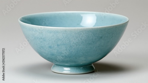 Delicate celadon ceramic bowl rests on a subtle pedestal base.